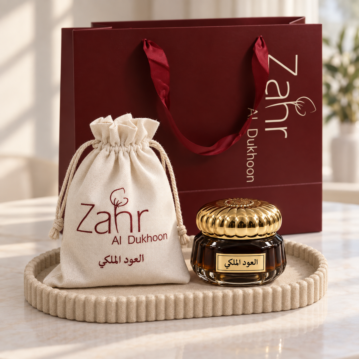 Aloud Almalaki bakhoor jar beside its named ivory pouch and burgundy Zahr shopping bag